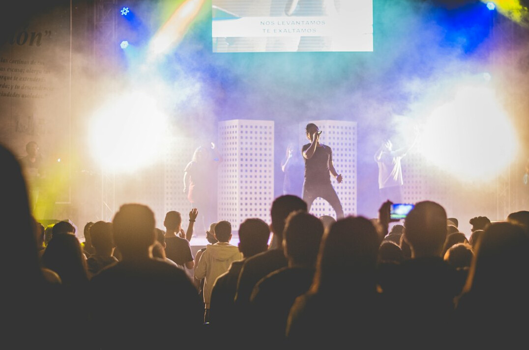 Speaker presenting to an audience in a dimly lit conference hall